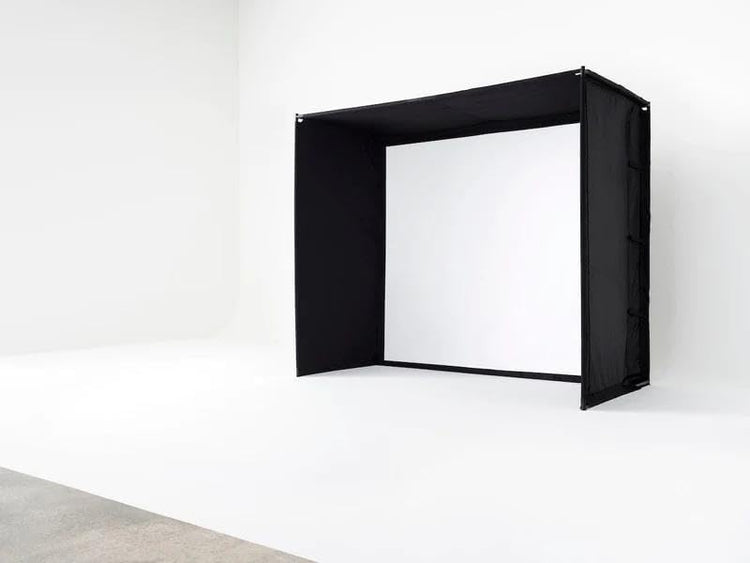 Golf simulator enclosure with black side panels and a white impact screen.